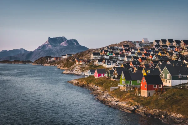 A breathtaking view of Disko Island's rugged coastline with towering basalt cliffs.