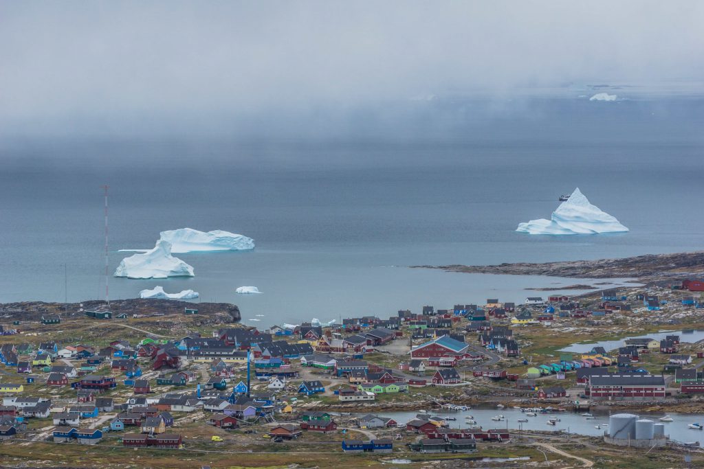 A traditional Inuit fishing village on Disko Island, nestled among fjords and mountains. 